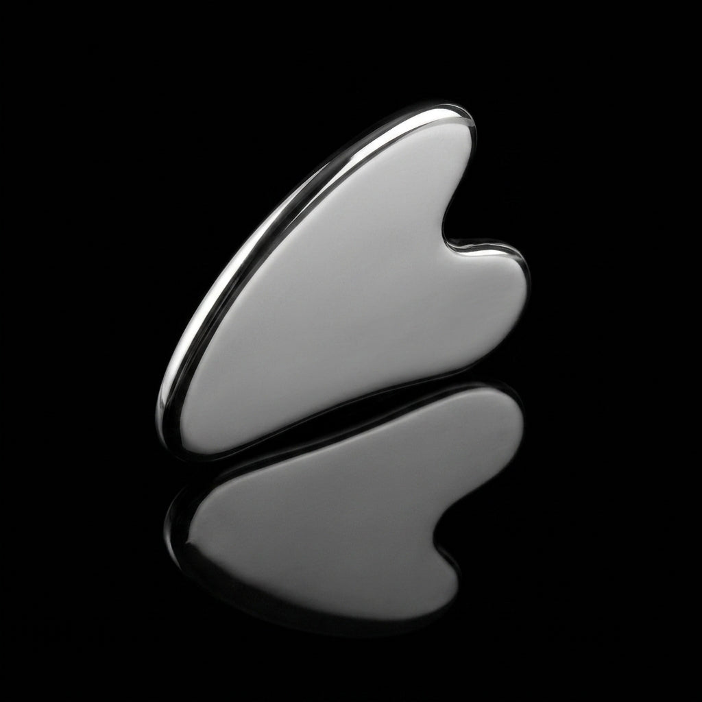 Gua sha acier inoxydable, reflet métallique sur fond noir
